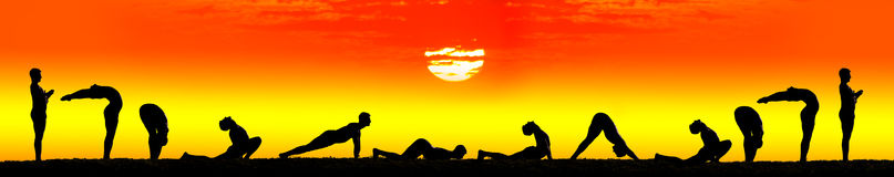 A group of people laying on the ground in front of an orange sky.