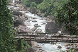 A bridge over a river with rocks and trees